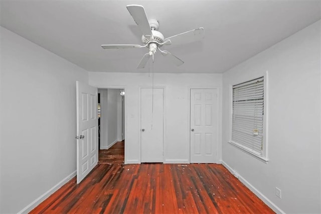 unfurnished bedroom featuring ceiling fan and dark hardwood / wood-style floors