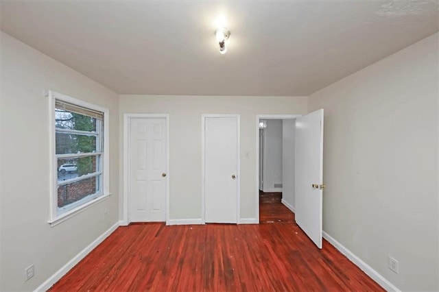 unfurnished bedroom with dark wood-type flooring