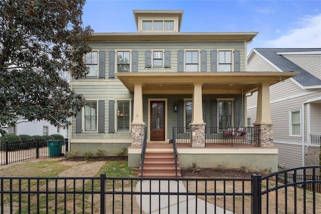 american foursquare style home with covered porch and a fenced front yard