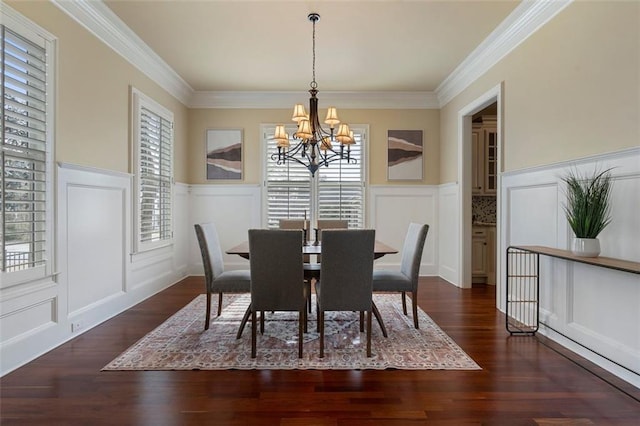 dining area featuring crown molding, dark hardwood / wood-style floors, and a chandelier