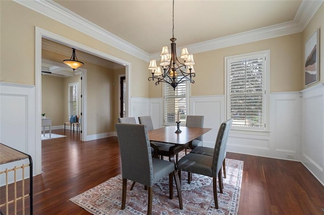 dining space with ornamental molding, a notable chandelier, and dark hardwood / wood-style flooring