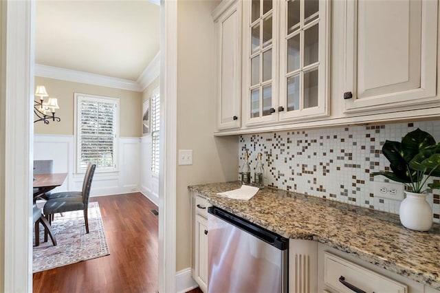 kitchen with white cabinetry, light stone countertops, ornamental molding, and stainless steel dishwasher