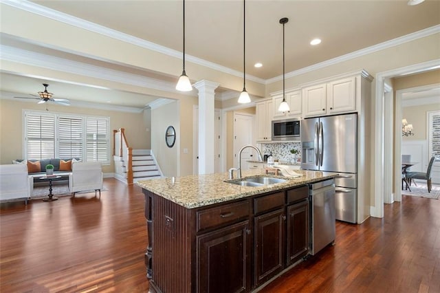 kitchen featuring sink, decorative light fixtures, ornamental molding, appliances with stainless steel finishes, and white cabinets