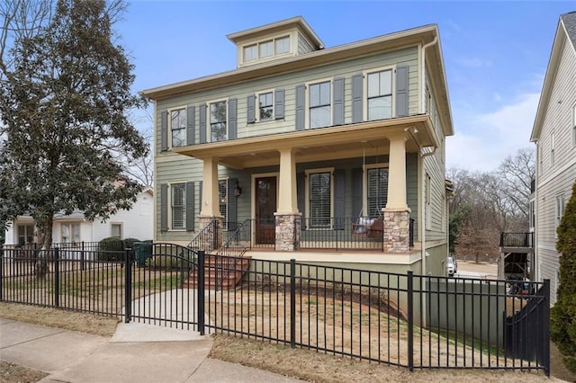 traditional style home featuring covered porch and a fenced front yard