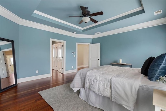 bedroom with crown molding, dark hardwood / wood-style floors, a raised ceiling, and ceiling fan