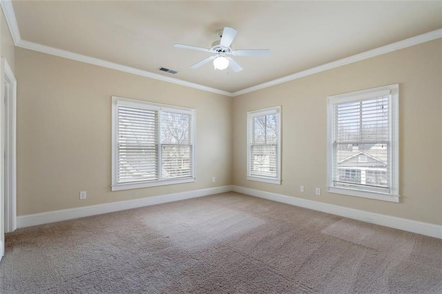 carpeted spare room featuring crown molding, a wealth of natural light, and ceiling fan