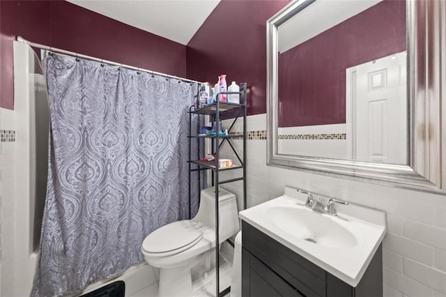 bathroom featuring tile patterned flooring, vanity, tile walls, and toilet