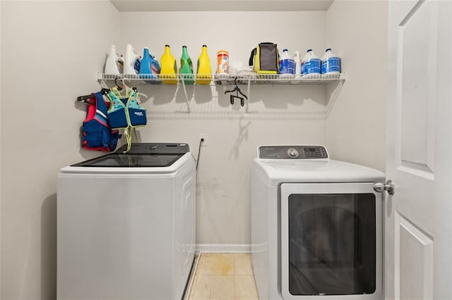 washroom with light tile patterned floors and washing machine and clothes dryer