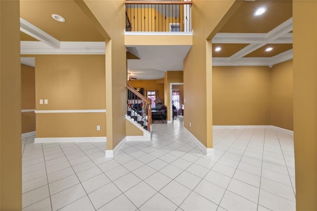 entrance foyer with tile patterned flooring, ornamental molding, and coffered ceiling