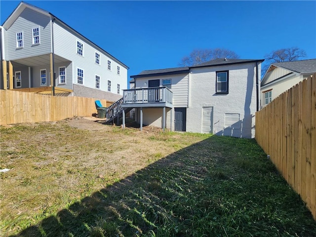 rear view of property featuring a wooden deck and a yard