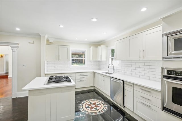 kitchen with appliances with stainless steel finishes, tasteful backsplash, white cabinetry, and sink