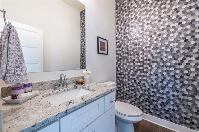 bathroom featuring vanity, hardwood / wood-style floors, and toilet