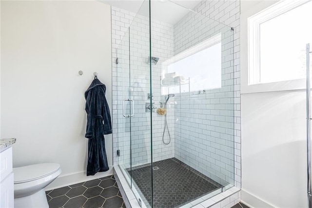 bathroom with tile patterned flooring, walk in shower, vanity, and toilet