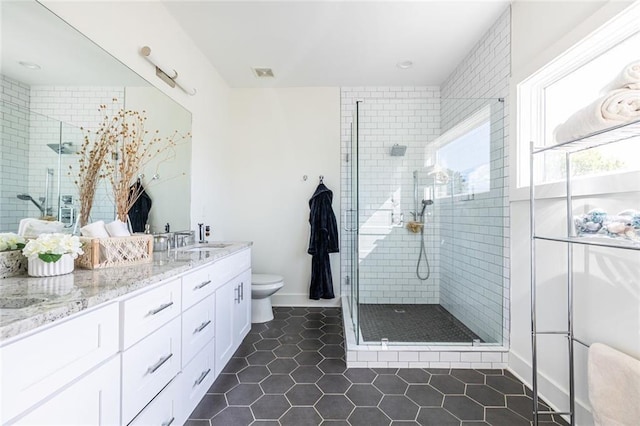 bathroom with vanity, a shower with shower door, tile patterned floors, and toilet