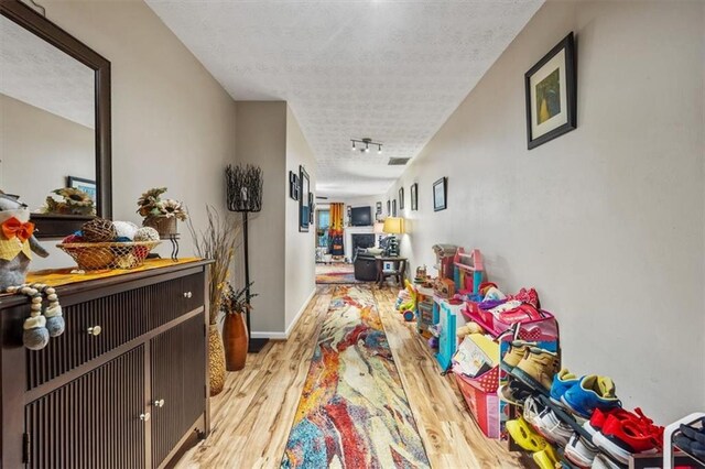 hallway featuring a textured ceiling and light wood-type flooring