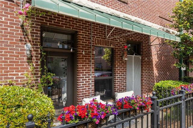 entrance to property with brick siding and fence