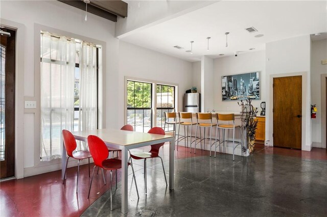 dining space featuring concrete flooring and visible vents