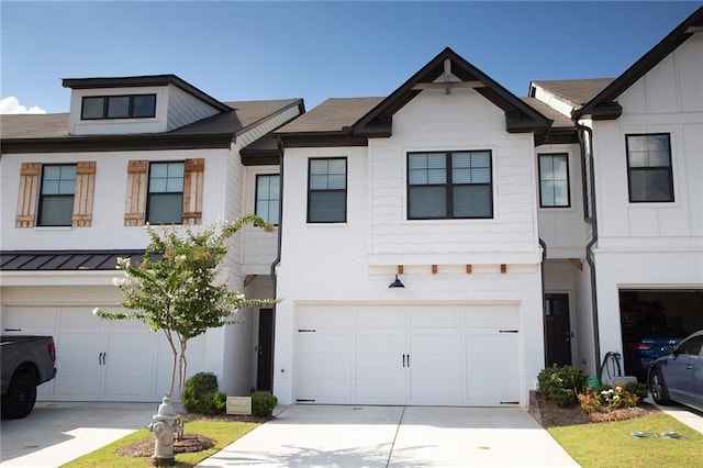 townhome / multi-family property featuring a garage, a standing seam roof, concrete driveway, and metal roof