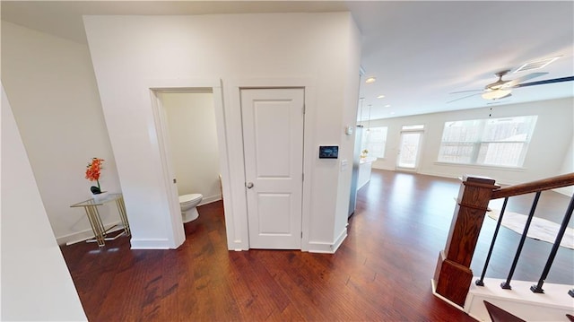 corridor featuring baseboards, recessed lighting, and wood finished floors