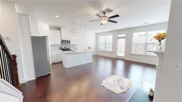 kitchen featuring decorative light fixtures, stainless steel appliances, dark hardwood / wood-style floors, an island with sink, and ceiling fan