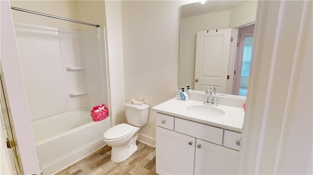 bathroom featuring vanity, wood finished floors, toilet, and shower / washtub combination