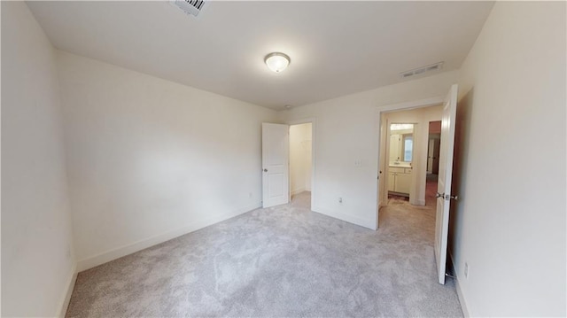 unfurnished bedroom with light colored carpet, baseboards, and visible vents