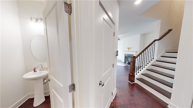hall featuring stairs, baseboards, and wood finished floors