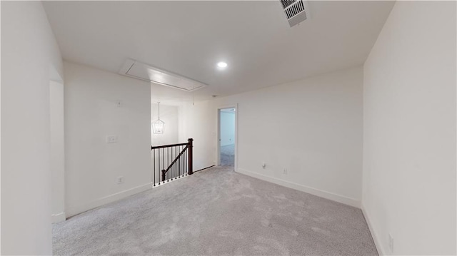 carpeted empty room featuring visible vents, attic access, baseboards, and recessed lighting