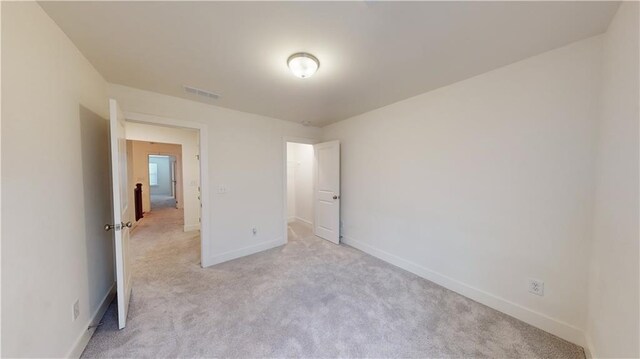 unfurnished bedroom featuring light carpet