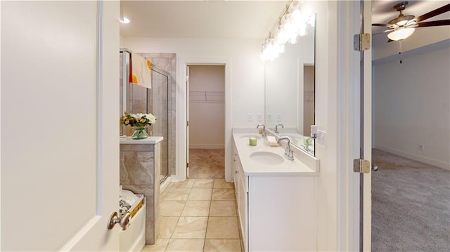 full bathroom with a walk in closet, a sink, double vanity, a ceiling fan, and a stall shower