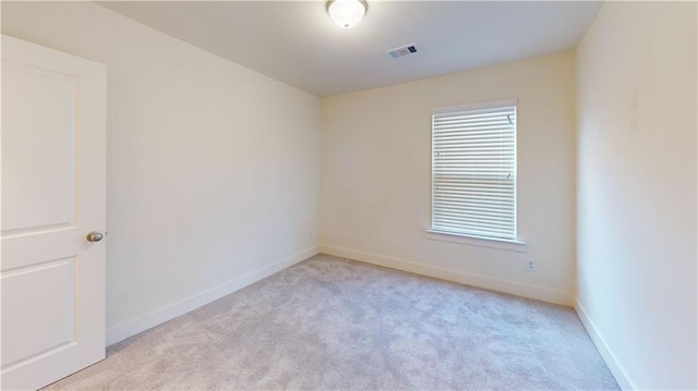 unfurnished room with baseboards, carpet flooring, and visible vents