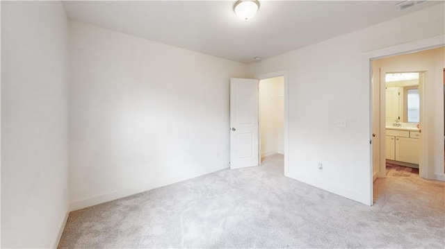 unfurnished bedroom with visible vents, light colored carpet, baseboards, a closet, and a spacious closet