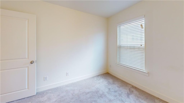 spare room featuring light colored carpet