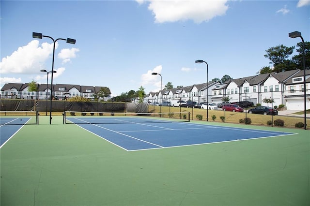 view of tennis court featuring a residential view, fence, and community basketball court