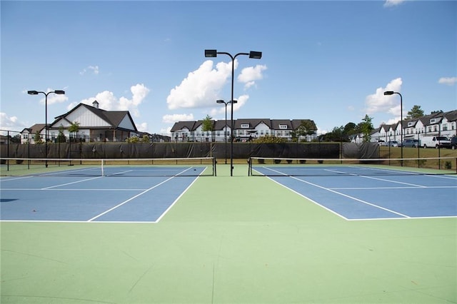 view of sport court featuring community basketball court, fence, and a residential view