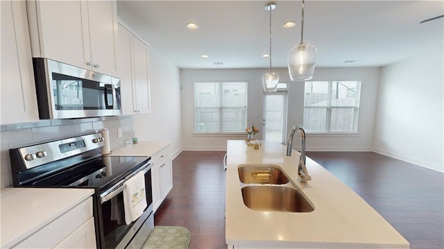 kitchen featuring a sink, dark wood-style flooring, appliances with stainless steel finishes, and light countertops