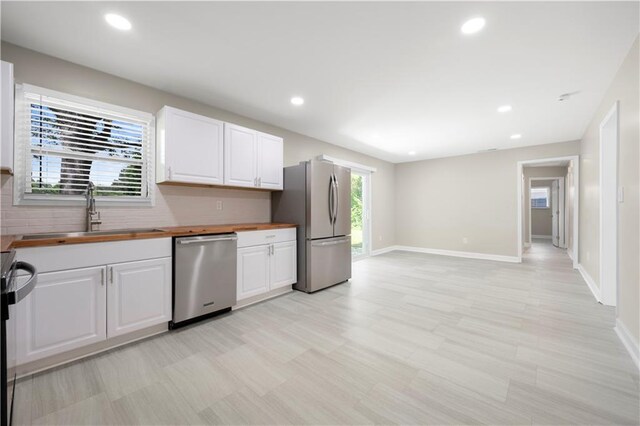 2159 Fairburn Rd SW, Atlanta, GA 30331 - kitchen featuring stainless steel appliances, a sink, butcher block countertops, white cabinets, and recessed lighting