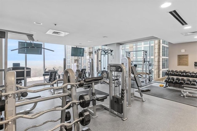 gym featuring a wall of windows, a healthy amount of sunlight, and visible vents