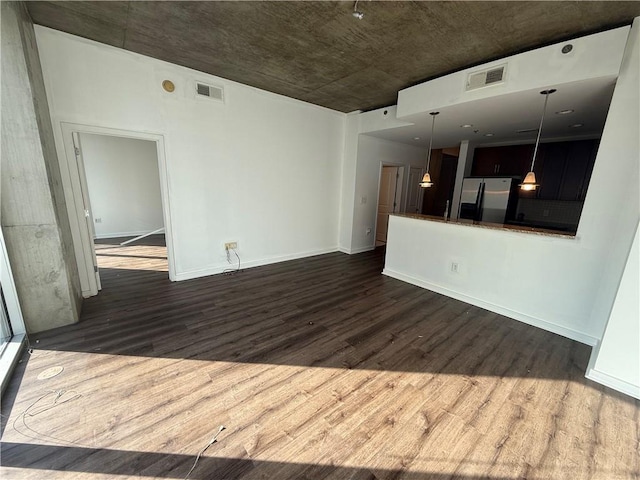 interior space with baseboards, visible vents, and dark wood-type flooring