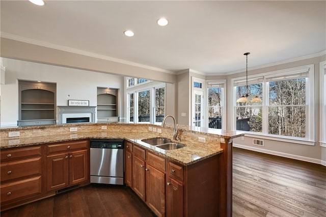 kitchen featuring pendant lighting, stainless steel dishwasher, crown molding, and sink