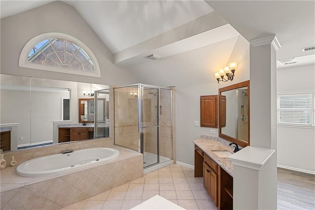 bathroom with vanity, separate shower and tub, an inviting chandelier, and vaulted ceiling