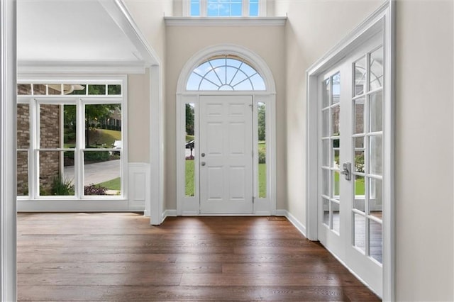 foyer featuring french doors, a towering ceiling, and dark wood-type flooring