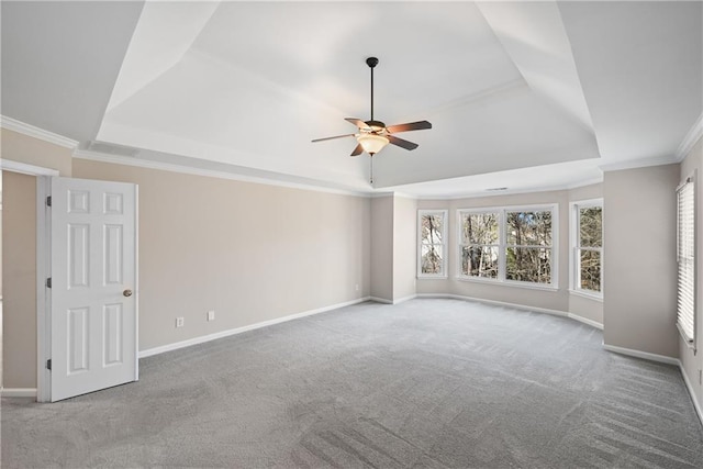 carpeted spare room with a tray ceiling, ceiling fan, and ornamental molding