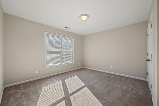 spare room with dark colored carpet