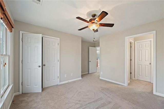 unfurnished bedroom featuring ceiling fan and light carpet