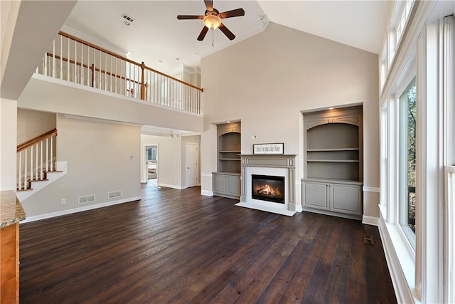 unfurnished living room with ceiling fan, dark hardwood / wood-style flooring, and high vaulted ceiling