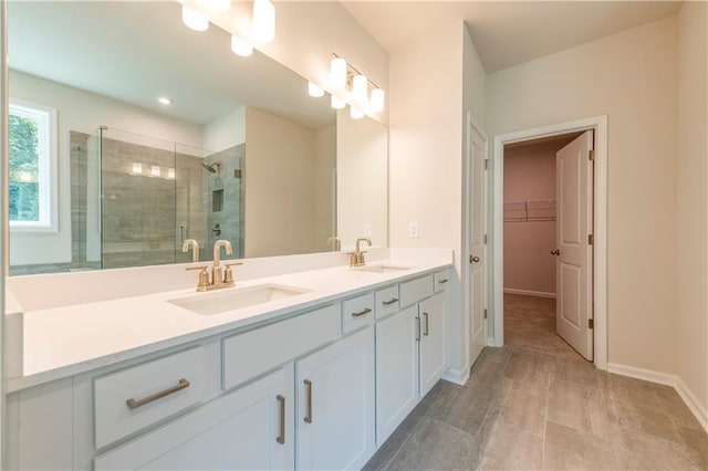 7505 Woolf Way, Cumming, GA 30028 - bathroom featuring double vanity, a shower stall, a spacious closet, and baseboards