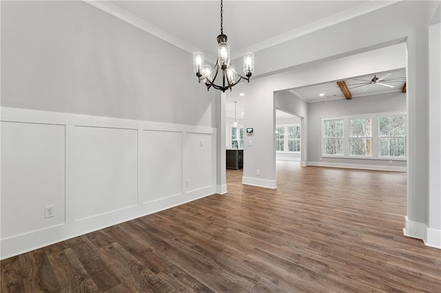 unfurnished dining area with ceiling fan with notable chandelier, dark hardwood / wood-style flooring, and crown molding