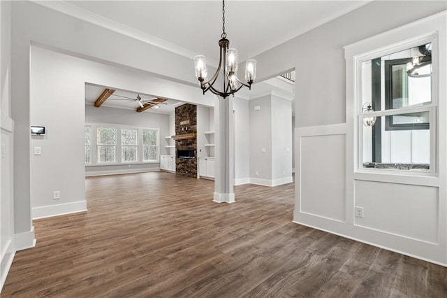 unfurnished dining area with beam ceiling, dark hardwood / wood-style flooring, built in features, a fireplace, and ceiling fan with notable chandelier