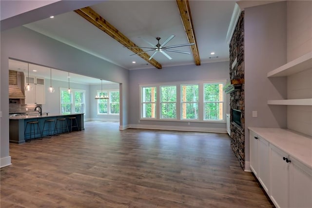 6449 Snelling Mill Rd, Flowery Branch, GA 30542 - unfurnished living room featuring ceiling fan, a fireplace, beamed ceiling, a sink, and baseboards